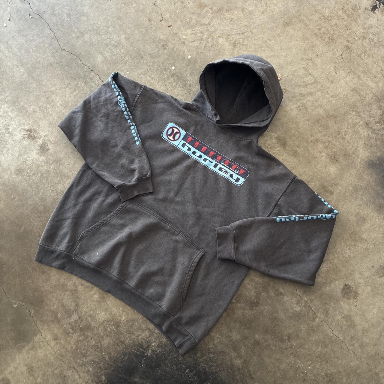Faded black Hurley graphic hoodie laid on concrete