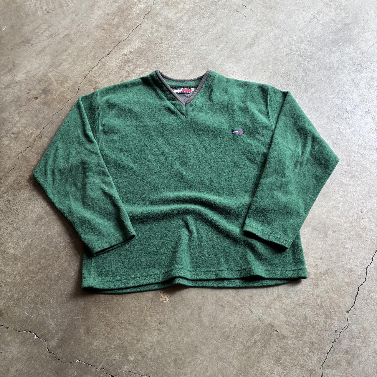 Green Tommy Hilfiger fleece laid on concrete